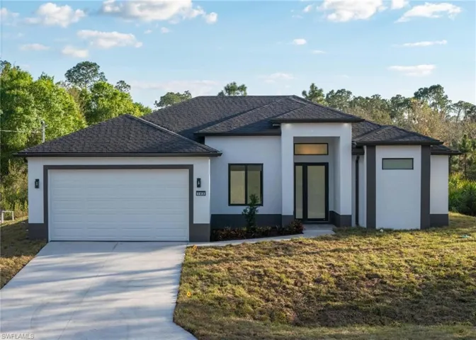 View of front of property featuring a garage and a front yard