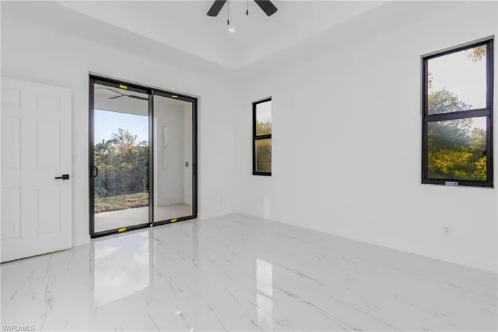 Master room featuring a tray ceiling, a wealth of natural light, and ceiling fan