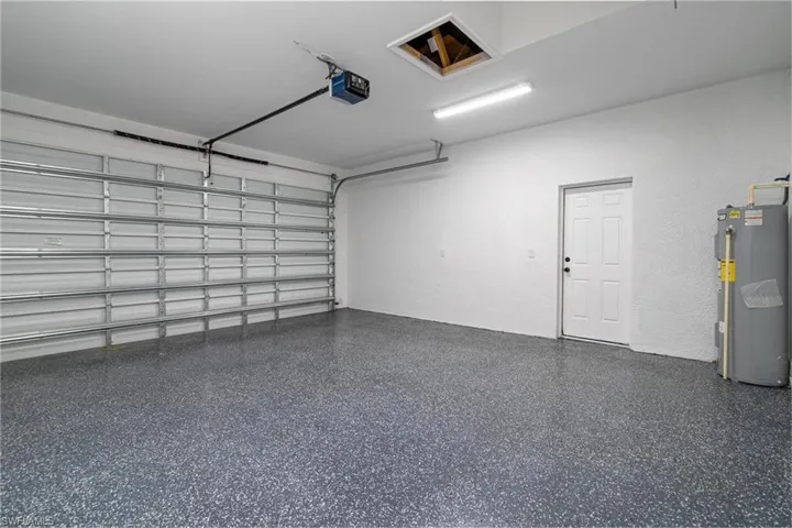 Garage featuring a garage door opener and water heater