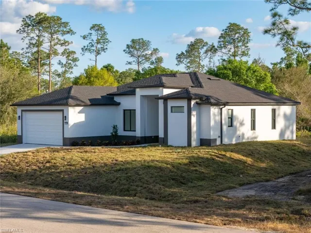 View of front of house with a garage and a front yard