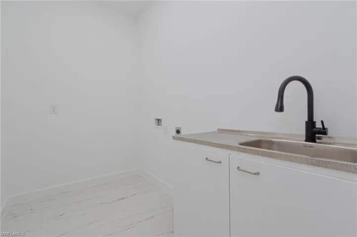 Laundry area with cabinets, washer hookup, sink, and electric dryer hookup
