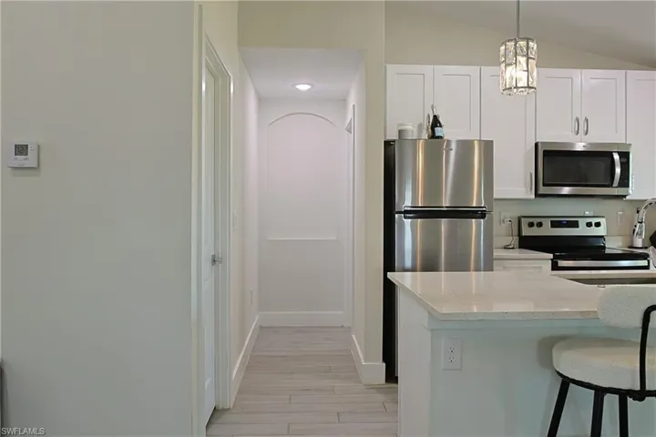 Kitchen featuring white shaker cabinetry, stainless steel appliances, and light-toned countertops