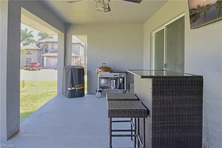 Covered patio featuring a ceiling fan, concrete flooring, and sliding glass door access