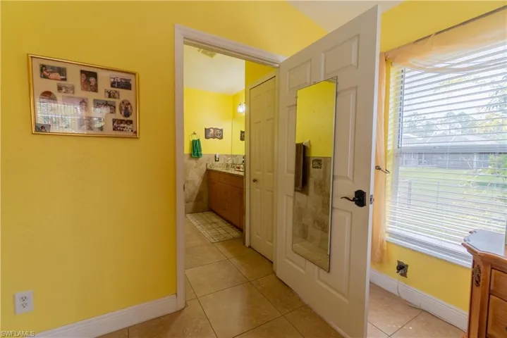 Corridor with baseboards, light tile patterned floors, and plenty of natural light