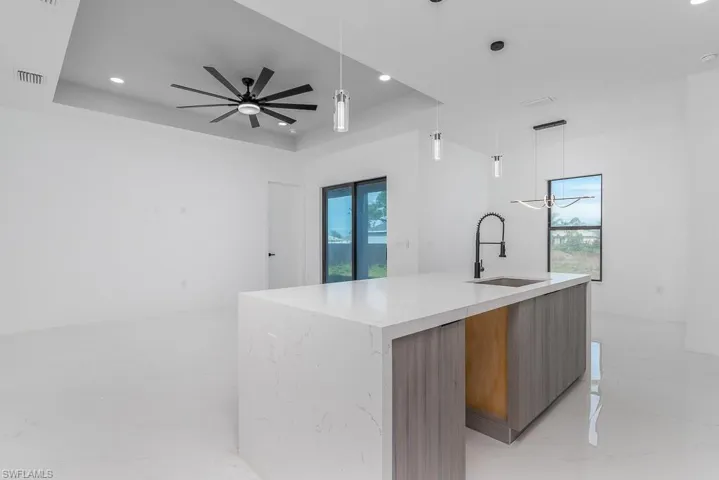 Kitchen with marble finish floor, a raised ceiling, modern cabinets, and a sink