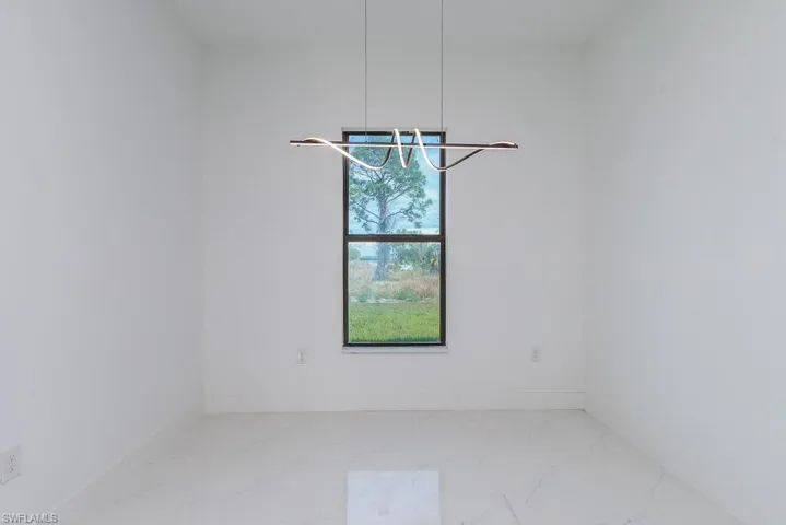 Unfurnished room featuring marble finish floor and baseboards
