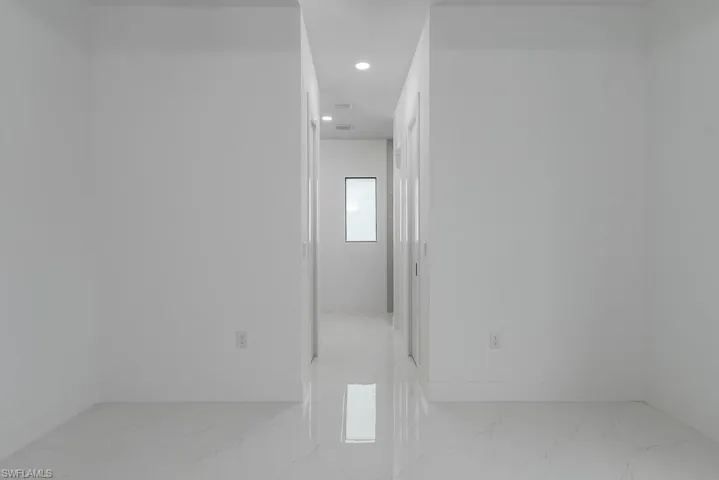 Empty room with marble finish floor, baseboards, and recessed lighting