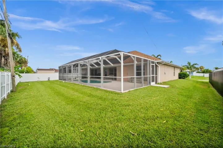 Back of property featuring a fenced backyard, a sunroom, and glass enclosure