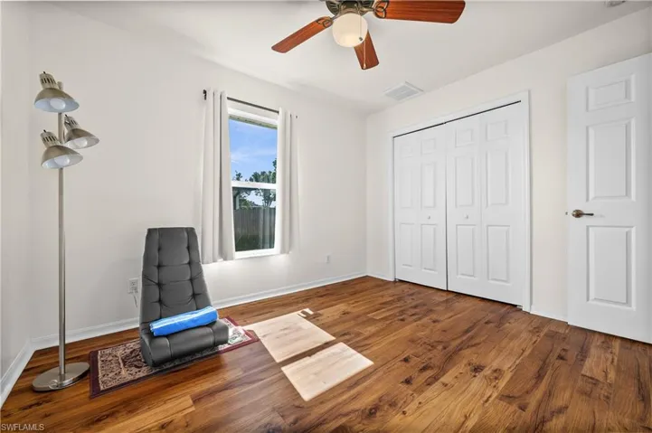 Unfurnished room featuring dark wood-type flooring and a ceiling fan