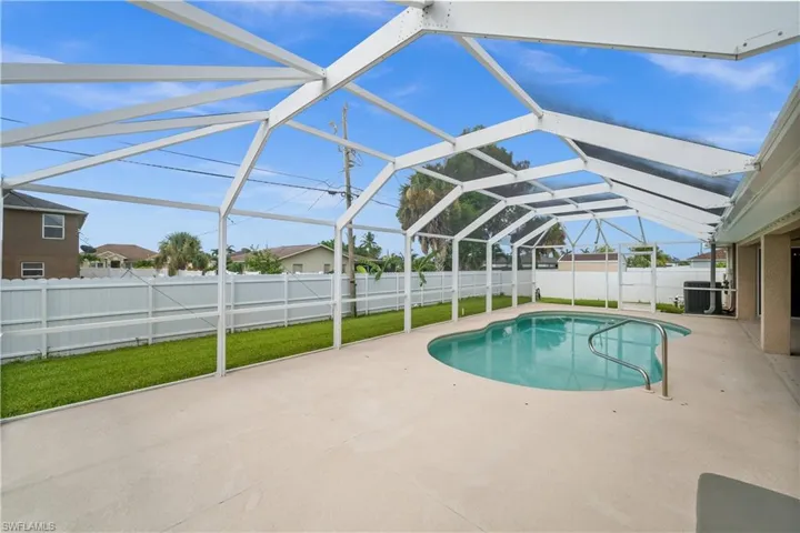 View of pool featuring a patio area, a sunroom, glass enclosure, and a fenced backyard