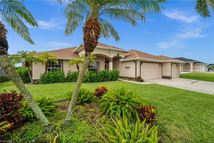 Mediterranean / spanish house with stucco siding, an attached garage, concrete driveway, and a front yard