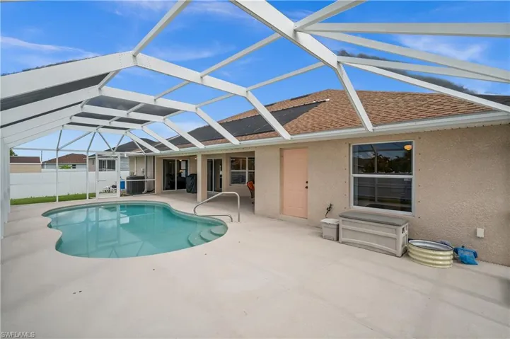 Back of property with a sunroom, a patio, glass enclosure, roof with shingles, and stucco siding