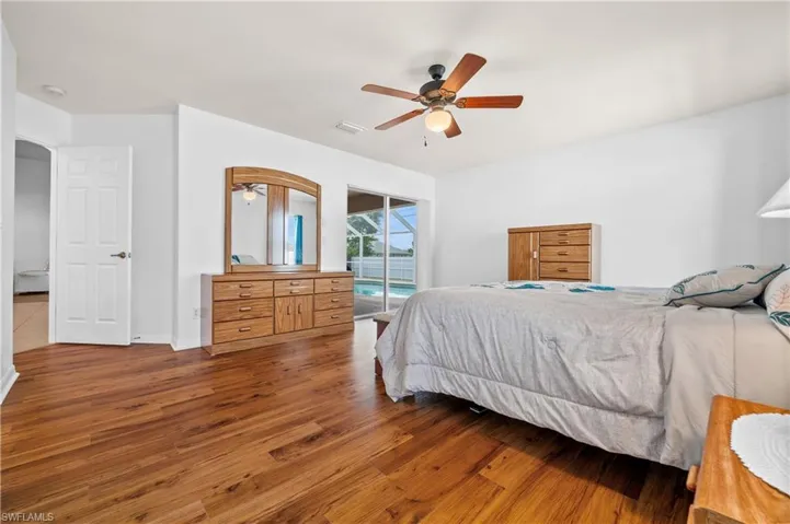 Bedroom with wood finished floors, access to exterior, and ceiling fan