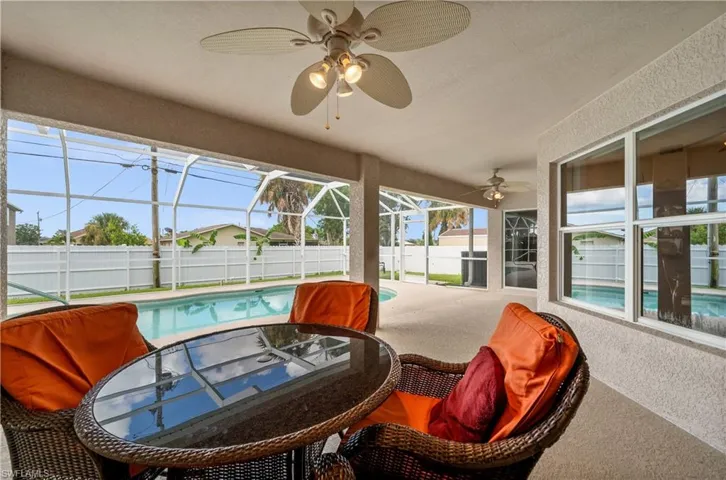 Fenced backyard featuring a sunroom, a patio, glass enclosure, and ceiling fan