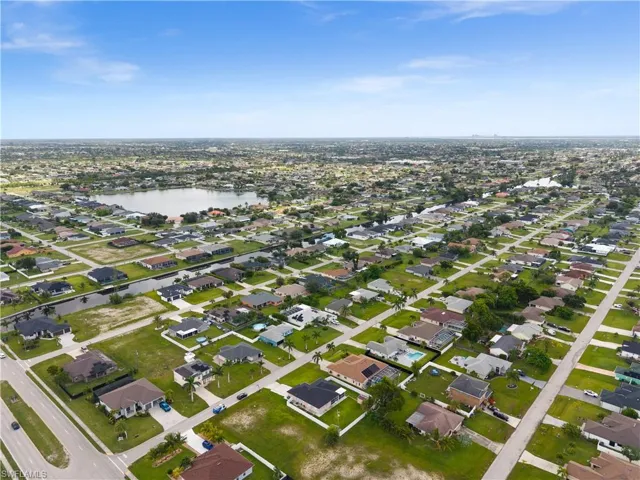 Aerial view of property and surrounding area featuring a large body of water and nearby suburban area