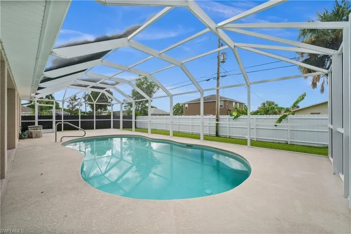 View of swimming pool with a patio area, glass enclosure, a sunroom, and a fenced backyard