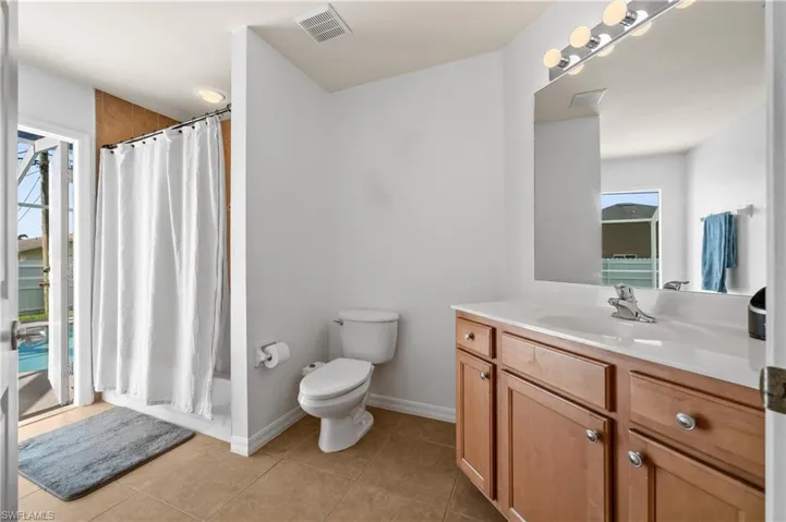 Full bath with vanity, light tile patterned floors, and shower / tub combo with curtain