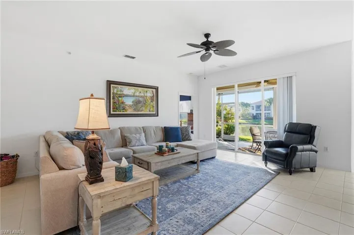 Living area featuring light tile patterned floors and ceiling fan