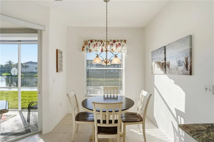 Dining space featuring a chandelier, light tile patterned floors, healthy amount of natural light, and a water view