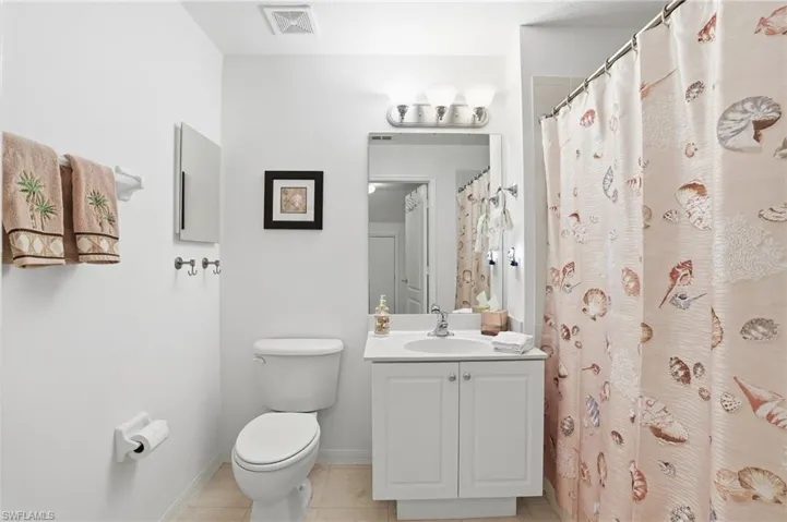 Bathroom featuring a shower with curtain, vanity, and light tile patterned flooring