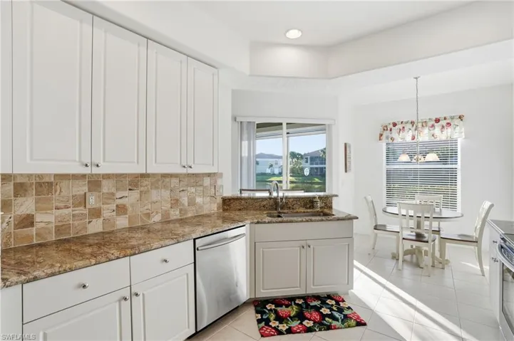 Kitchen with stainless steel appliances, white cabinetry, light tile patterned floors, decorative backsplash, and recessed lighting