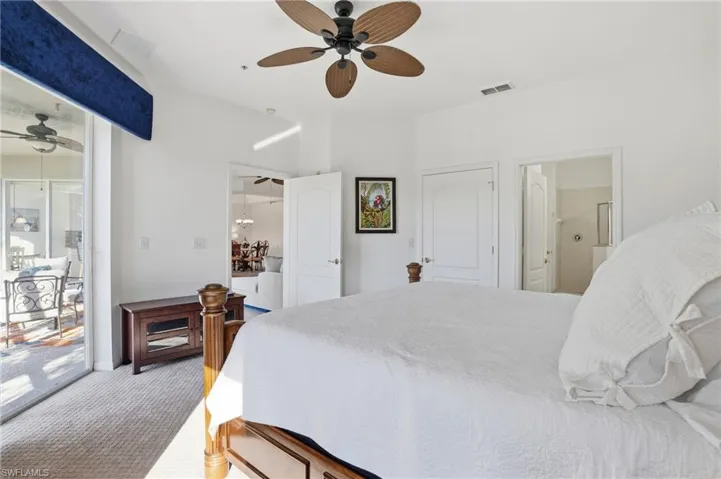 Bedroom featuring light colored carpet, ensuite bath, a ceiling fan, and access to outside
