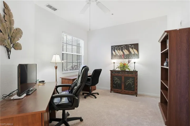 Office space featuring light carpet and a ceiling fan