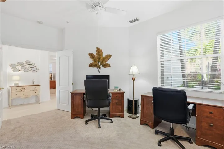 Home office featuring a ceiling fan and light carpet
