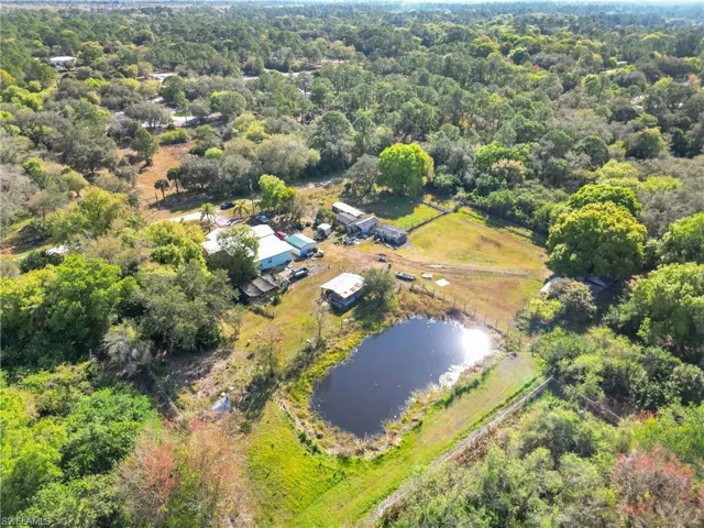 Aerial overview of property's location featuring a large body of water and a heavily wooded area