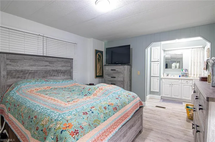 Bedroom featuring light wood finished floors and ensuite bathroom