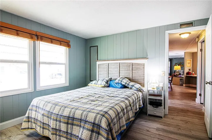 Bedroom with wood finished floors and baseboards