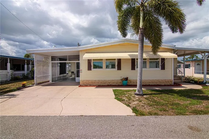 Manufactured / mobile home featuring an attached carport and driveway