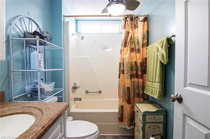 Full bathroom featuring toilet, vanity, and shower / tub combo