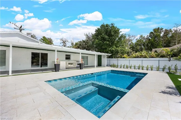 Combined pool / hot tub featuring a fenced backyard and a patio