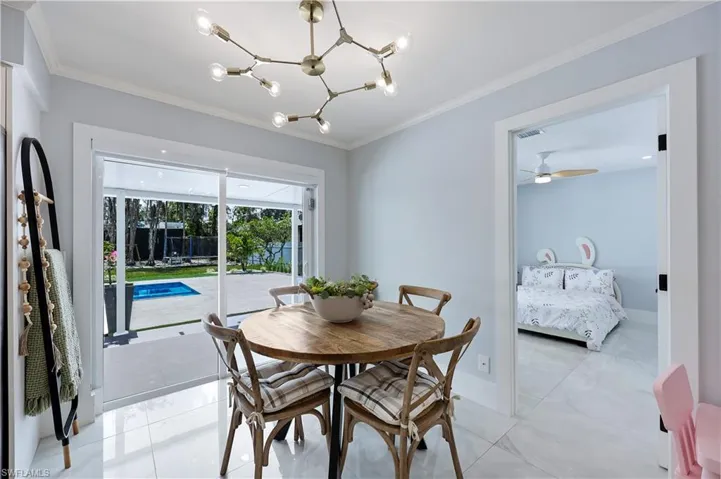 Dining room with crown molding, a chandelier, and a ceiling fan