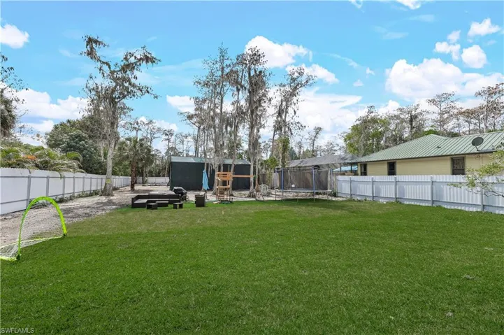Fenced backyard with a trampoline, a storage shed, and a patio
