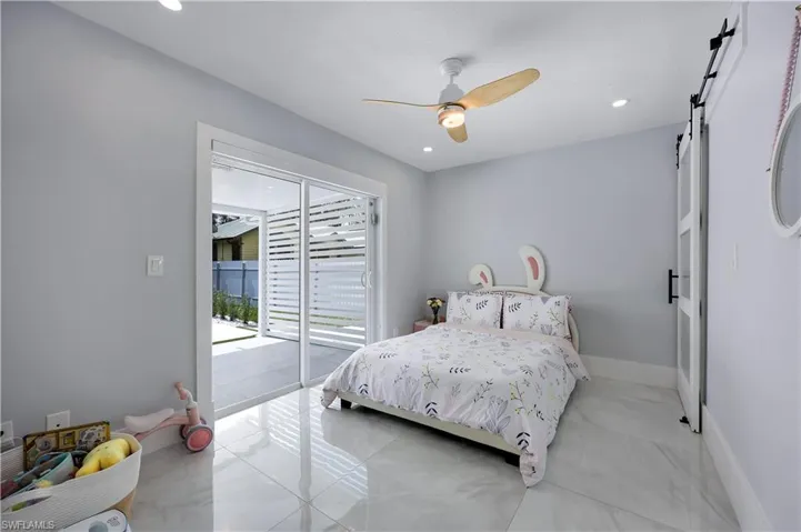 Bedroom featuring a barn door, access to outside, a ceiling fan, and recessed lighting