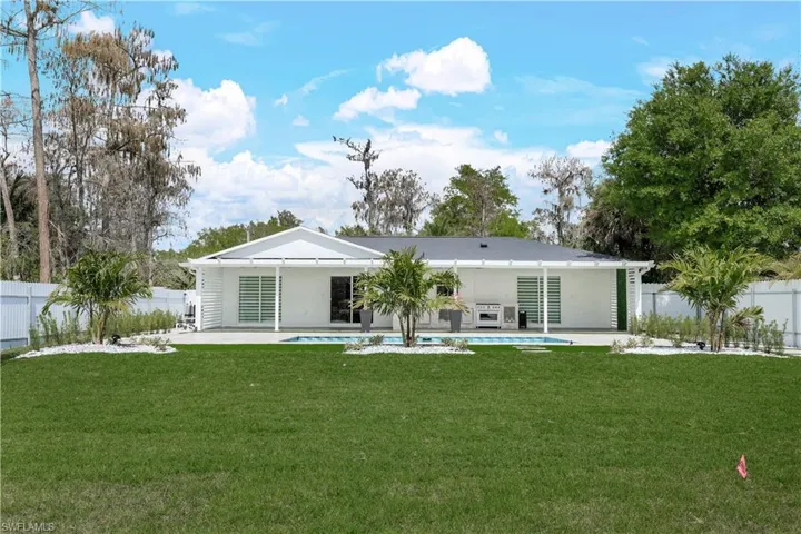 Rear view of property with a fenced backyard, a patio, and stucco siding