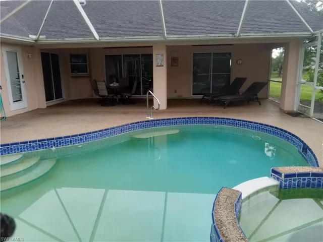 View of pool with a pool with connected hot tub, a lanai, and a patio area