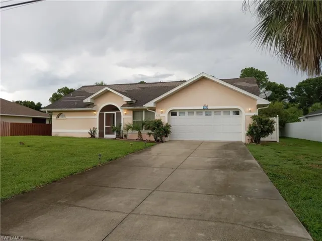 Ranch-style house featuring stucco siding, a garage, driveway, and a shingled roof