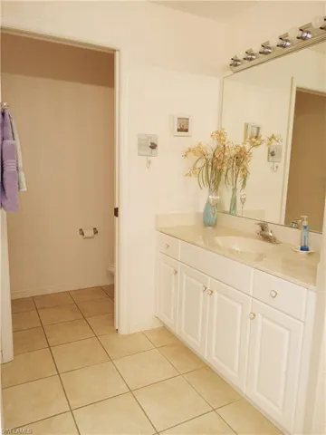 Bathroom with vanity, tile patterned floors, toilet, and baseboards
