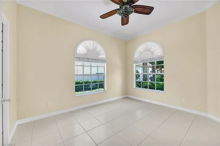 Den with two arched windows with privacy blinds