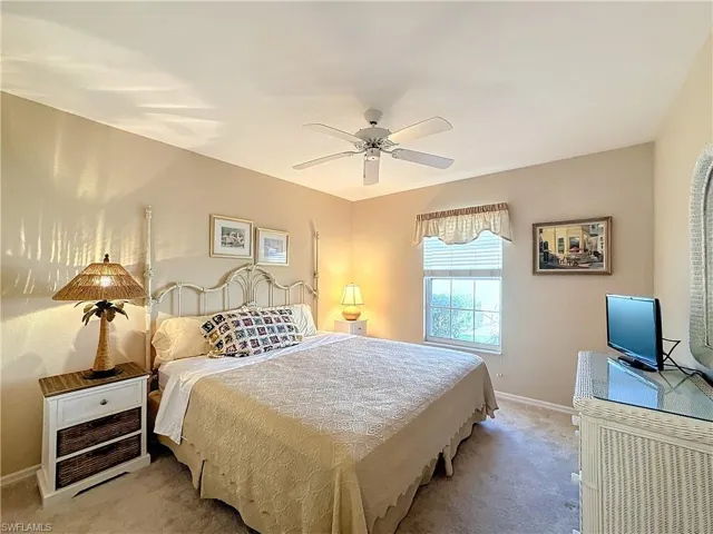 Carpeted bedroom featuring ceiling fan