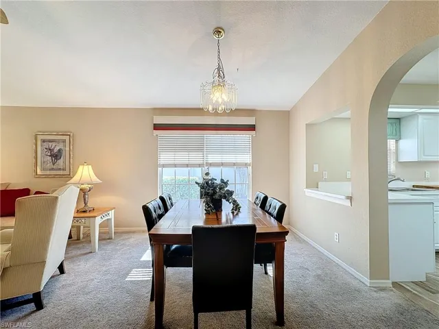 Carpeted dining room featuring a notable chandelier