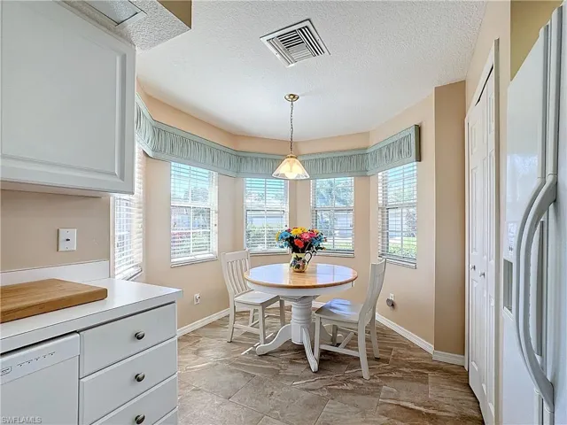 Tiled dining room featuring a wealth of natural light and a textured ceiling