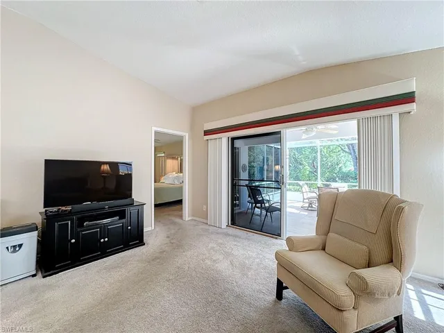 Carpeted living room featuring vaulted ceiling