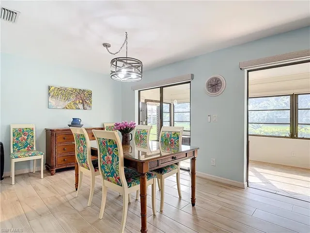 Dining area with plenty of natural light, an inviting chandelier, and natural wood porcelain plank tile.