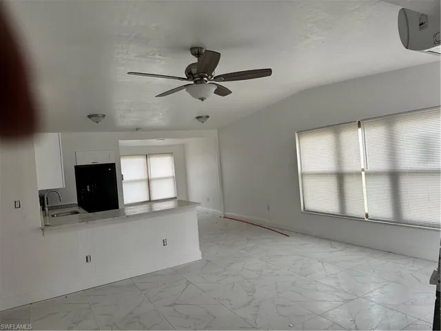 Unfurnished living room with ceiling fan and light marble finish flooring