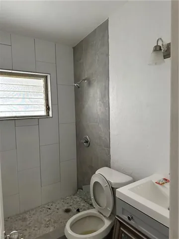 Full bath with vanity, a stall shower, and a textured wall