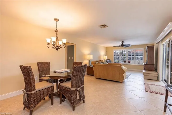 Open-concept living space with tile flooring, a decorative chandelier, and recessed lighting